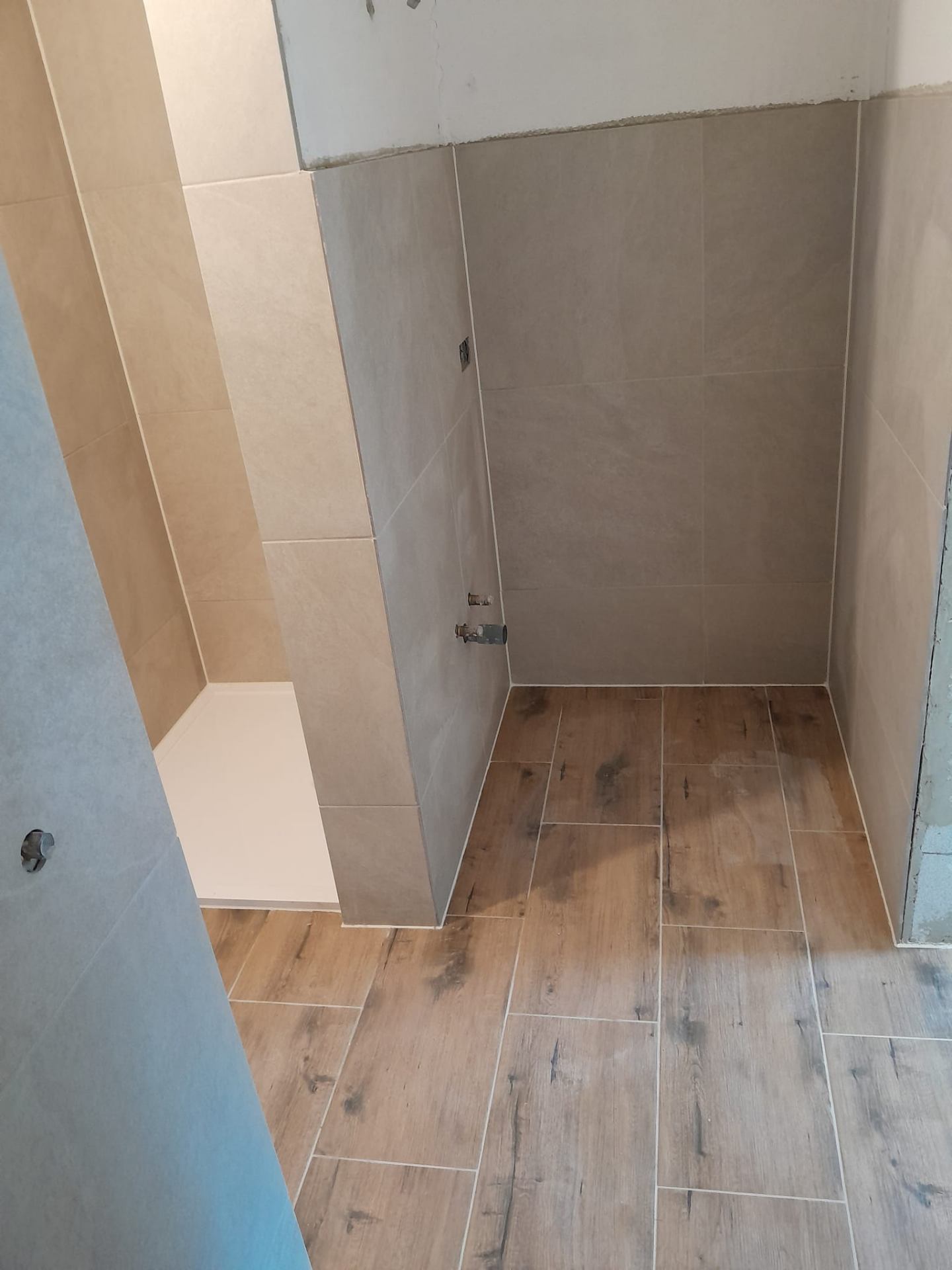 Begehbare Dusche mit beigen Wandfliesen und Bodenfliesen in Holzoptik